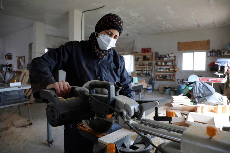 A Palestinian woman works at a carpentry shop in Al Walajah village, close to the West Bank city of Bethlehem. Five years ago, a group of housewives began recycling waste timber into usable products, which were sold to souvenir shops. AFP