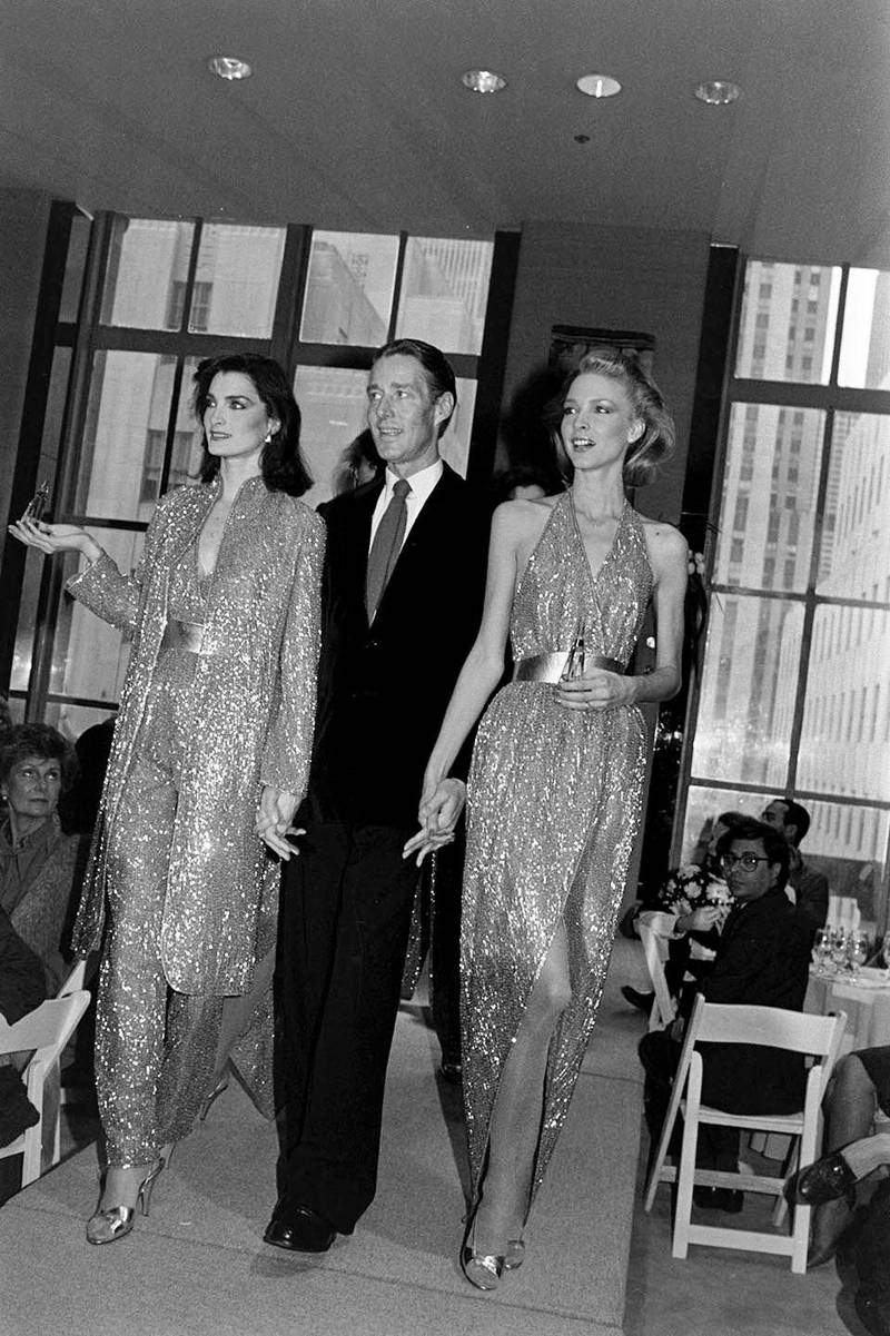 Designer Roy Halston with models Karen Bjornson and Margaret Donohue in looks from the Halston Made to Order Spring 1981 collection.