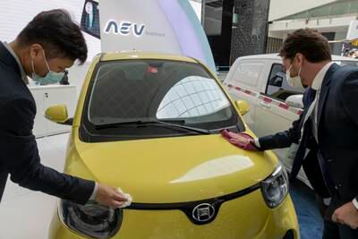 Visitors check out an electric vehicle at the show.
