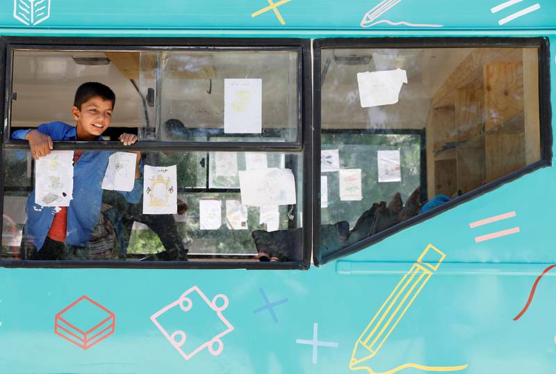 A school boy looks out of a mobile library bus window.