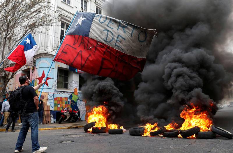 Tyres burn on a road as dockworkers protest against Chile's government seeking to block an approval made by lawmakers that would allow citizens to make another withdrawal from their privately-held pension savings to combat economic hardship generated by the coronavirus disease pandemic, in Valparaiso, Chile. Reuters