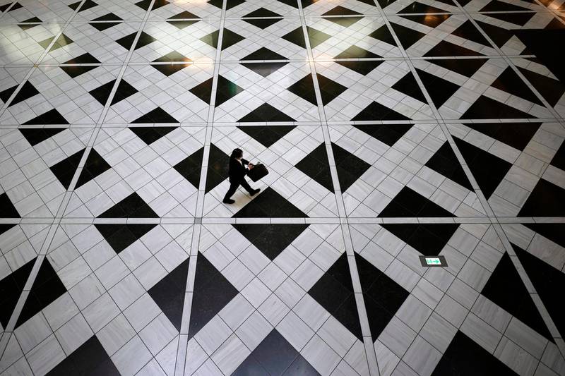 A man wearing a face mask to help curb the spread of the coronavirus walks through a building in Tokyo. AP Photo