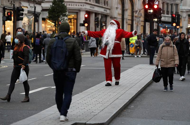 A man dressed as Santa Claus walks among shoppers on Regent street in London. Reuters