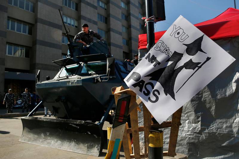Lebanese policeman sits on his armored personal carrier, as they arrive to open a main highway which was blocked by anti-government protesters during ongoing protests against the Lebanese government, in Beirut, Lebanon. AP Photo