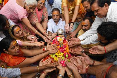 Devotees pay respect to an idol of Krishna during the Janmashtami festival at a temple in Amritsar, India. AFP