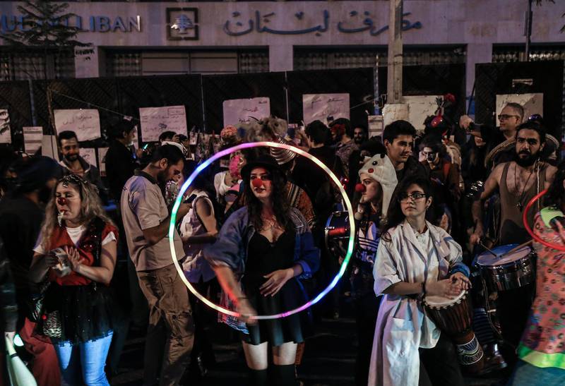 epa08020862 Lebanese protesters dressed in clown costumes play music, perform comics, and hand out leaflets against bank policy during an anti-government protest in front of Lebanese Central Bank at Hamra Street in Beirut, Lebanon, 23 November 2019. Protests in Lebanon are continuing since first erupted on 17 October, as protesters aim to apply pressure on the country's political leaders over what they view as a lack of progress following the resignation of Prime Minister Saad Hariri on 29 October.  EPA/NABIL MOUNZER