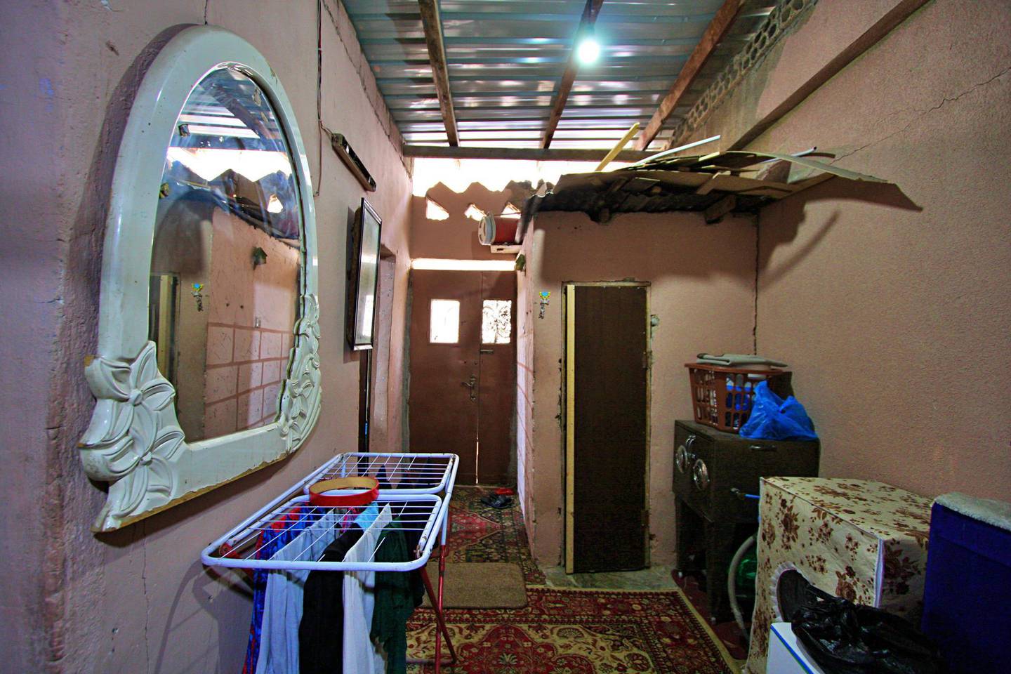 The bathroom can be seen on the right and where a gaping hole remains above Fathia Al Jawabrah's front door. Charlie Faulkner