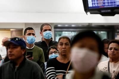 Raphael Hidalgo and his friends wear surgical mask as a preventive measure in light of the coronavirus outbreak in China, as they wait for their Venezuelan friend who will be arriving from a flight from Miami at Benito Juarez international airport in Mexico City, Mexico January 24, 2020. REUTERS/Carlos Jasso