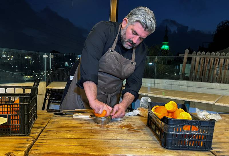 Omar Sartawi squeezes an orange before processing it to produce a type of leather.