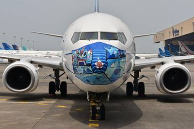 A Garuda Indonesia Boeing 373-800 NG with a new face mask design as part of a campaign to  promote the wearing of face masks amid the Covid-19 coronavirus, is parked at the airport in Tangerang. AFP