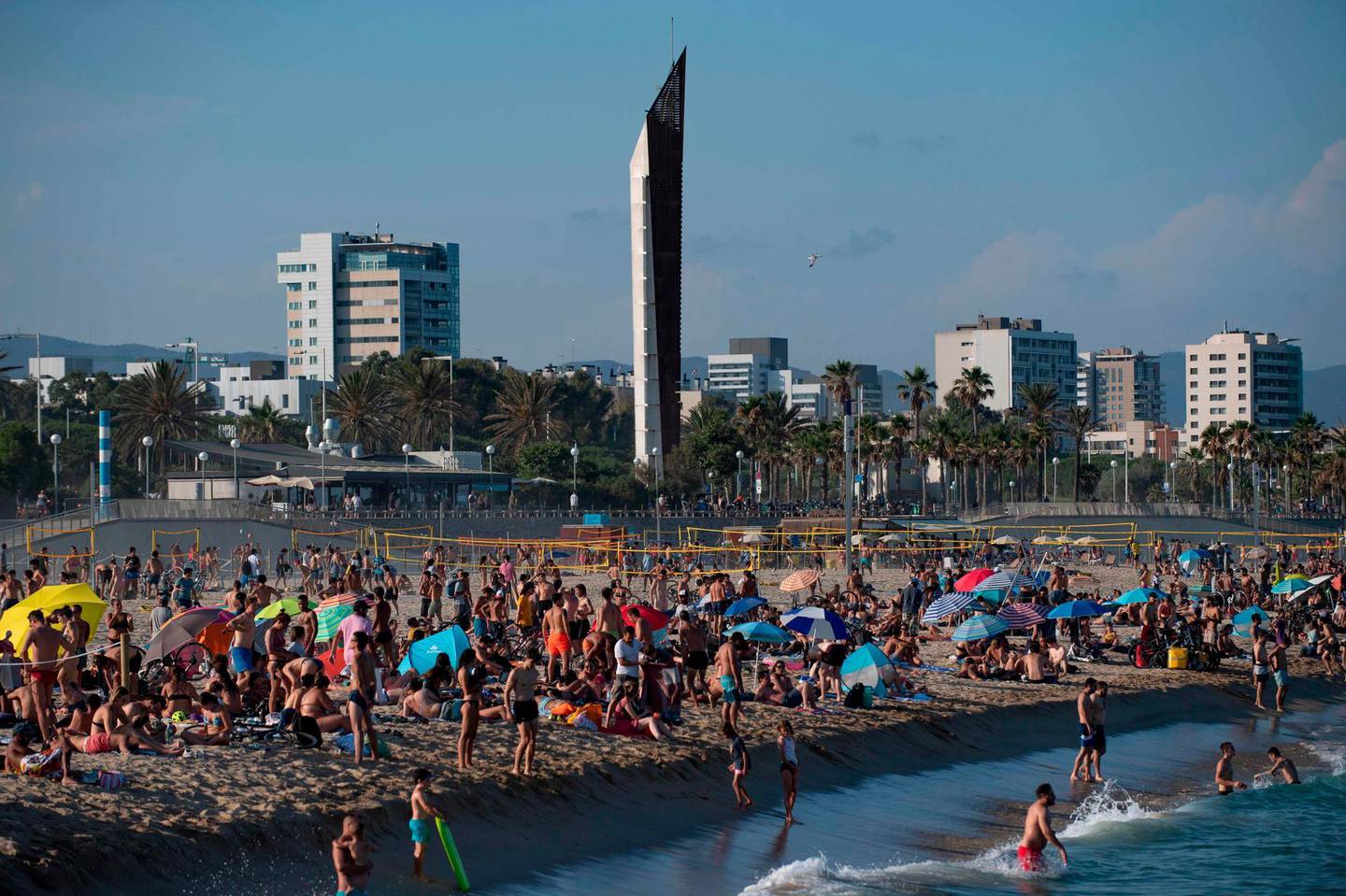 People enjoy a day at El Bogatell Beach in Barcelona on July 1, 2020.  The European Union reopened its borders to visitors from 15 countries but excluded the United States, where coronavirus deaths are spiking once again, six months after the first cluster was reported in China.  / AFP / Josep LAGO
