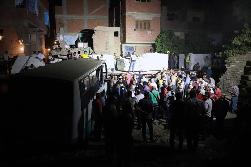 People stand near a cargo train that crashed into two minibuses, in Kafr Al Elw, south of Cairo, Egypt, on June 21, 2021. EPA