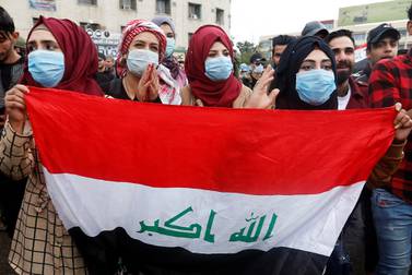 Iraqi women carry the national flag during anti-government protests in Baghdad on February 25, 2020. Reuters 