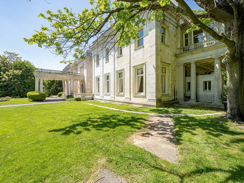 The property includes sweeping lawns with classic sculptures