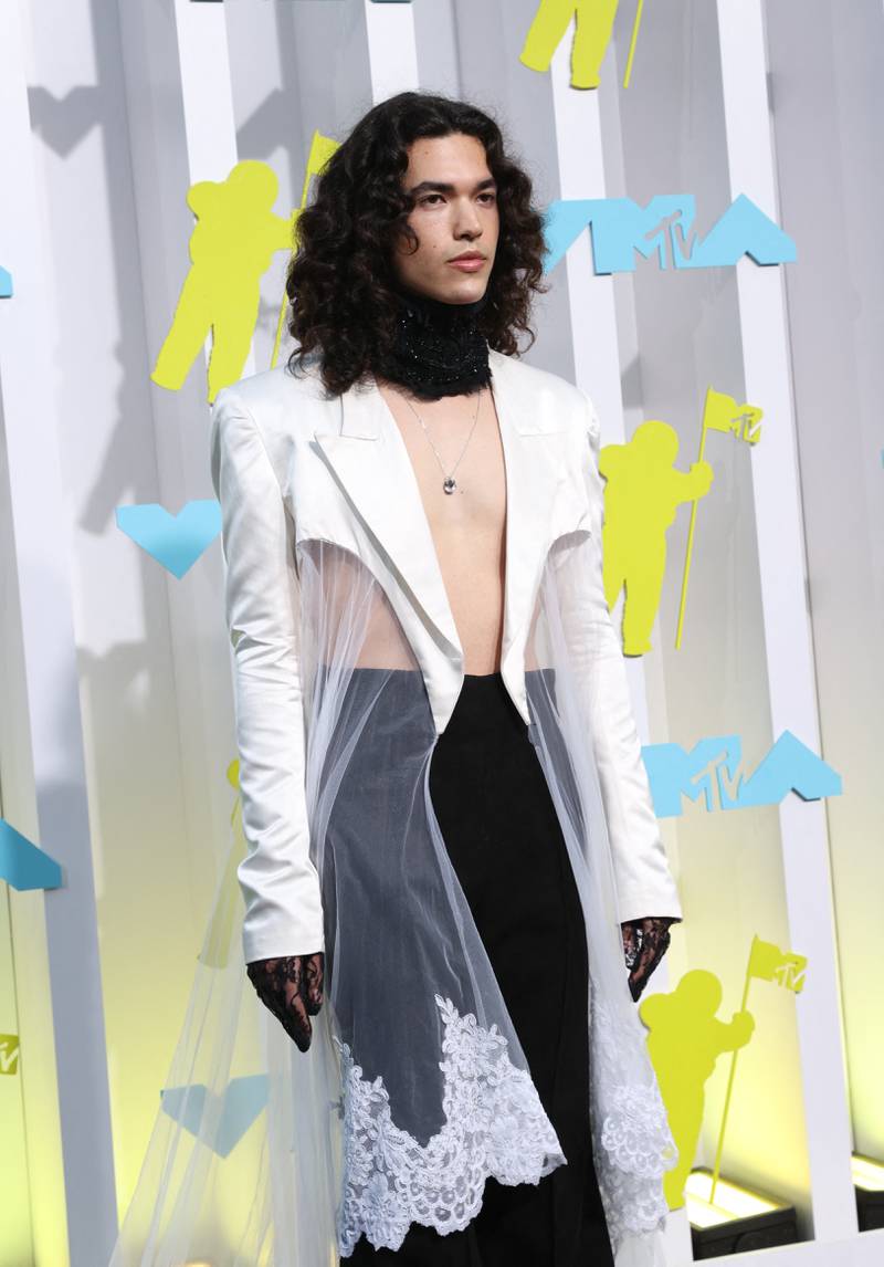 Conan Gray wears a sheer white duster jacket over black trousers. Reuters 