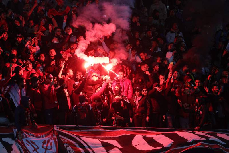 Al Ahly supporters set off flares and cheer for the team inside the Ibn Batouta Stadium. AFP
