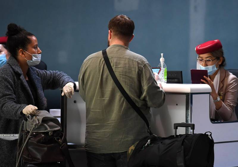 Passengers are assisted at the check-in counter in a terminal at Dubai International Airport.