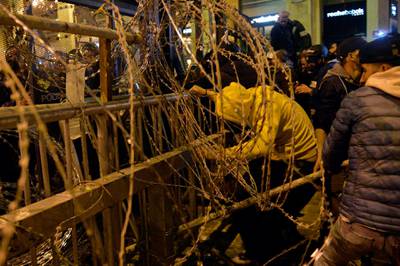 Anti-government protesters remove barbed wire during continuous anti-government protests outside of the Lebanese Parliament building in downtown Beirut.  EPA