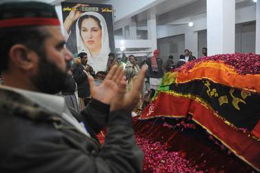 Pakistani peoples pray at the tomb of former prime minister Benazir Bhutto in Garhi Khuda Bakhsh on December 26, 2010, on her third death anniversary. Bhutto was assassinated almost exactly three years ago in a gun and suicide attack after addressing an election campaign rally in the garrison city of Rawalpindi, near the capital Islamabad, on December 27, 2007. In April, a UN panel accused the government of failing to provide Bhutto with adequate protection and said investigations were hampered by intelligence agencies and other officials who impeded "an unfettered search for the truth".  AFP PHOTO/Rizwan TABASSUM 