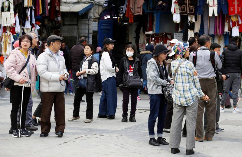 Tourists walk, one of them wearing a protective face mask, in the Old City of Tunis. Reuters