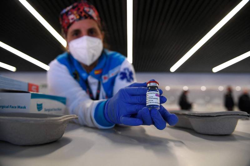 A health worker holds a bottle of the AstraZeneca vaccine against Covid-19 during a mass vaccination campaign by SUMMA 112 (Medical Emergency Services of Madrid) at the Wanda Metropolitan stadium in Madrid on February 25, 2021. So far, some 1.2 million people have been vaccinated in Spain since the start of the immunisation campaign which began just after Christmas with care home residents first in line along with their carers.  / AFP / PIERRE-PHILIPPE MARCOU
