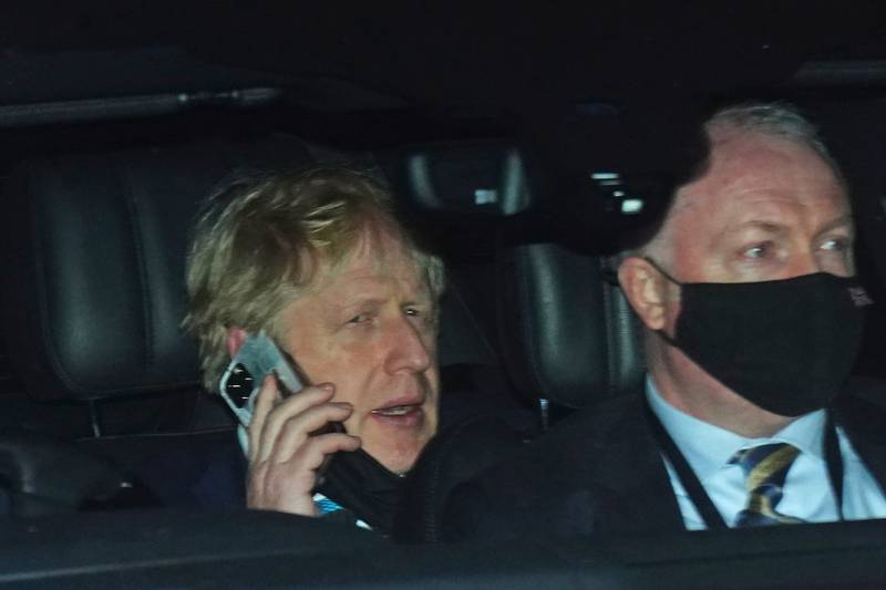 Prime Minister Boris Johnson, left, rides in the back seat of a government car as he returns to Downing Street on Wednesday following Prime Minister's Questions at the Houses of Parliament. No 10 is awaiting the submission of Sue Gray's report into possible lockdown breaches.