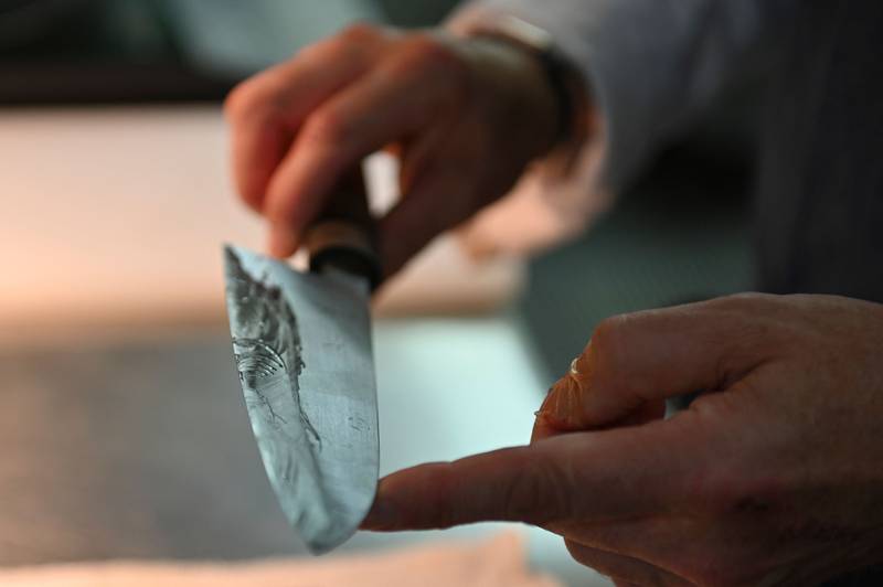 French chef Olivier Oddos cleaning a knife with whetstone at his restaurant in Tokyo
