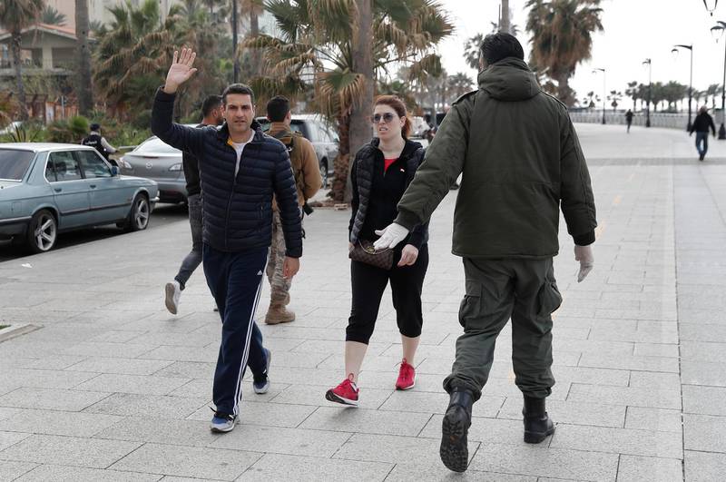 A municipal policeman, right, orders people to leave the waterfront promenade, along the Mediterranean Sea in Beirut. AP Photo