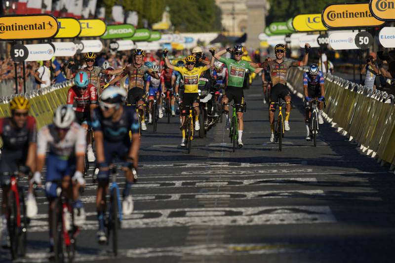 Tour de France winner Jonas Vingegaard crosses the finish alongside his Jumba-Visma teammates. AP