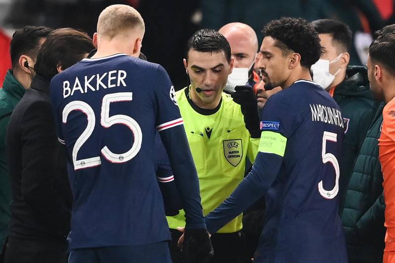 Referee Ovidiu Hategan passes by Paris Saint-Germain's Marquinhos (R) after the game was suspended amid allegations of racism by one of the match officials. AFP