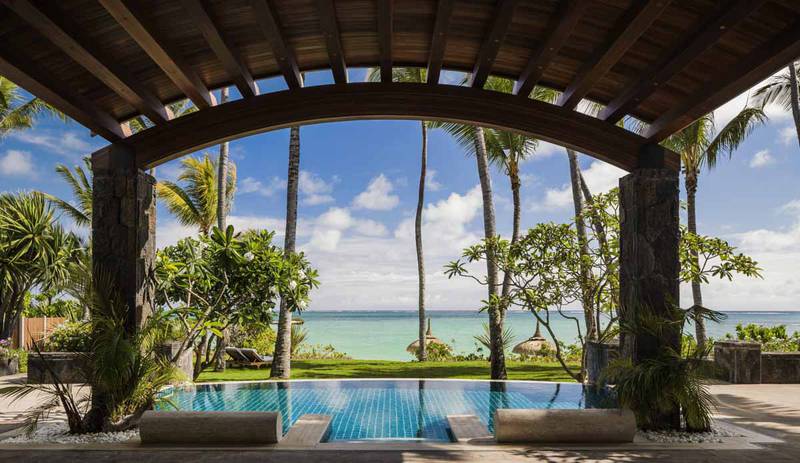 An infinity pool, palm trees and Indian Ocean views at One&Only Le Saint Geran, Mauritius. 