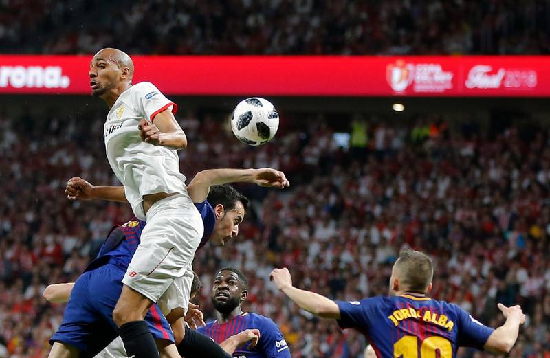 Sevilla's Steven N'Zonzi, left, jumps for the ball with Barcelona's Sergio Busquets during their Copa del Rey final at the Wanda Metropolitano stadium in Madrid. Paul White / AP Photo