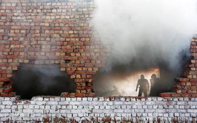 Firefighters try to douse a blaze at a footwear factory  in New Delhi. Adnan Abidi / Reuters