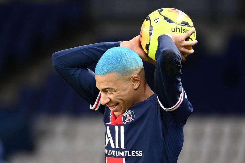 PSG's French forward Kylian Mbappe shows off his new blue hair as he takes a throw-in against Lorient. AFP