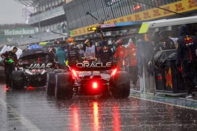 The cars line up in the pit lane in the rain as the race is suspended with a red flag. EPA 