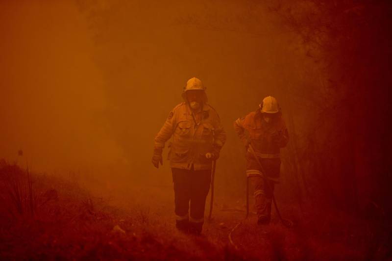 Firefighters tackle a bushfire in thick smoke in the town of Moruya, south of Batemans Bay, in New South Wales.  AFP