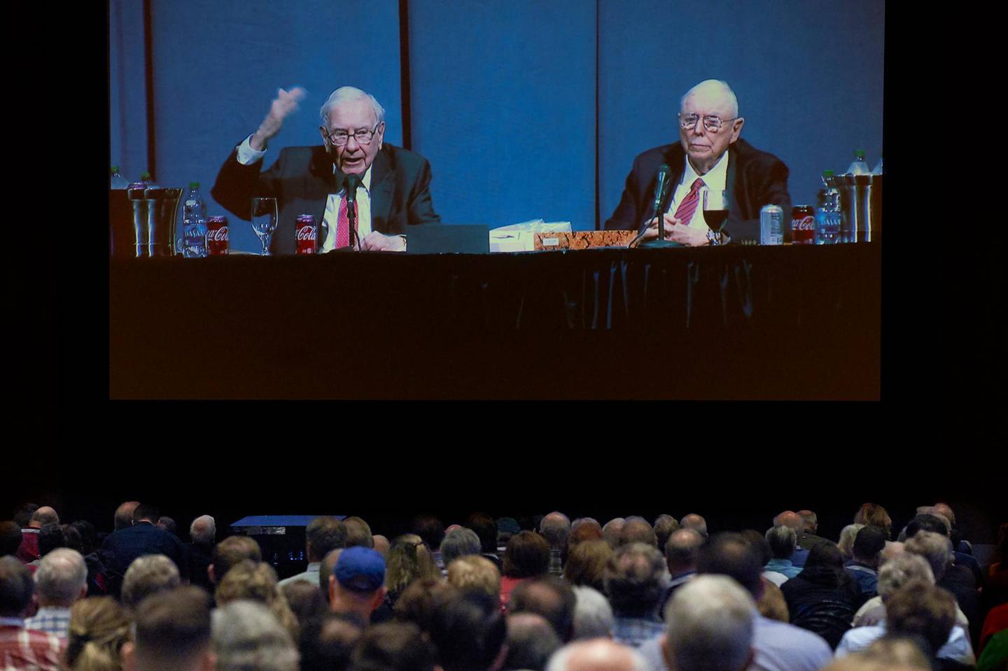 Shareholders in an overflow room watch on a big screen as Berkshire Hathaway Chairman and CEO Warren Buffett, left, and Vice Chairman Charlie Munger preside over the annual Berkshire Hathaway shareholders meeting in Omaha, Neb., Saturday, May 4, 2019. An estimated 40,000 people are thought to be in town for the event, where Buffett and Munger spend hours answering questions. (AP Photo/Nati Harnik)