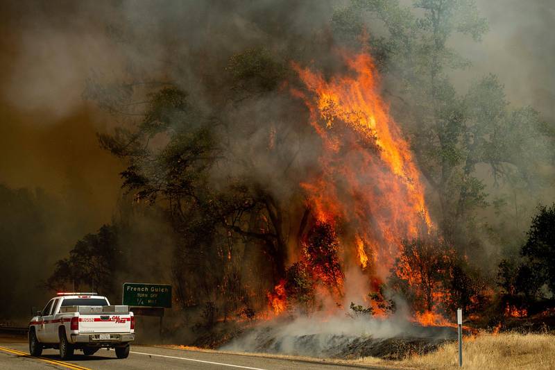 Flames from the Carr Fire lick above a Cal Fire truck in Whiskeytown, California. AP Photo / Noah Berger