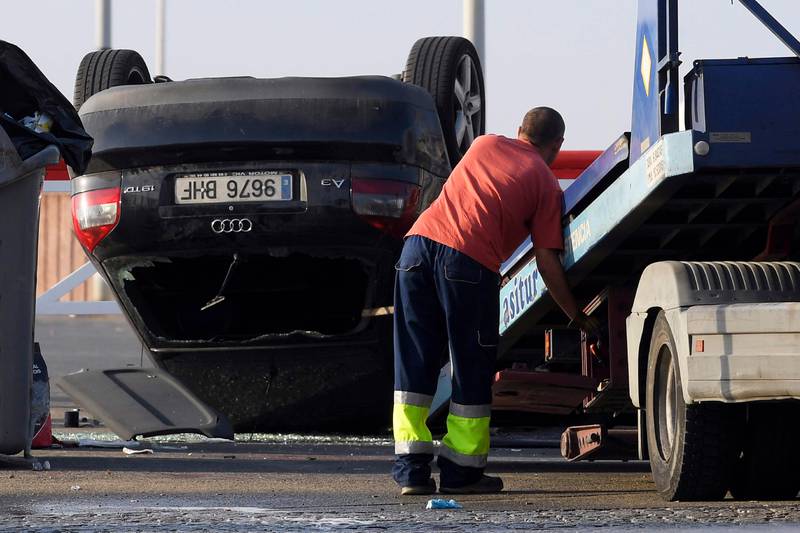 An employee starts to tow away a car involved in a terrorist attack in Cambrils, a city 120 kilometres south of Barcelona, on August 18, 2017.
Drivers have ploughed on August 17, 2017 into pedestrians in two quick-succession, separate attacks in Barcelona and another popular Spanish seaside city, leaving 13 people dead and injuring more than 100 others. In the first incident, which was claimed by the Islamic State group, a white van sped into a street packed full of tourists in central Barcelona on Thursday afternoon, knocking people out of the way and killing 13 in a scene of chaos and horror. Some eight hours later in Cambrils, a city 120 kilometres south of Barcelona, an Audi A3 car rammed into pedestrians, injuring six civilians -- one of them critical -- and a police officer, authorities said. / AFP PHOTO / LLUIS GENE