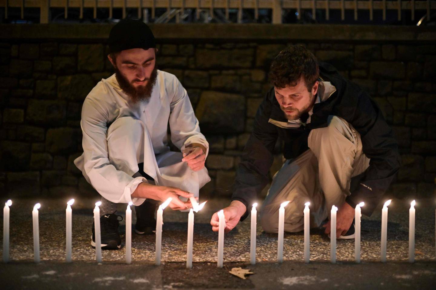 Well-wishers light 49 candles as they pay respects to victims outside the hospital in Christchurch on March 16, 2019, after a shooting incident at two mosques in the city the previous day. A right-wing extremist who filmed himself rampaging through two mosques in the quiet New Zealand city of Christchurch killing 49 worshippers appeared in court on a murder charge on March 16. / AFP / Anthony WALLACE
