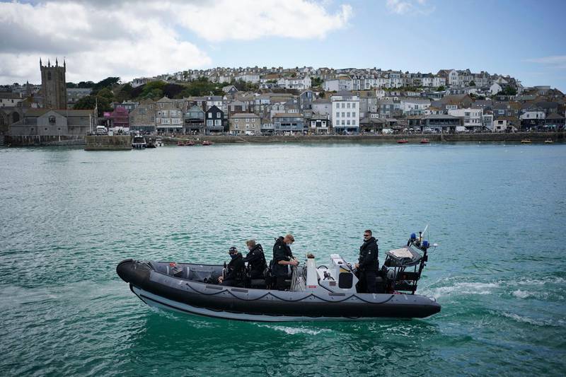 Police officers patrol the harbour in St. Ives. AP Photo