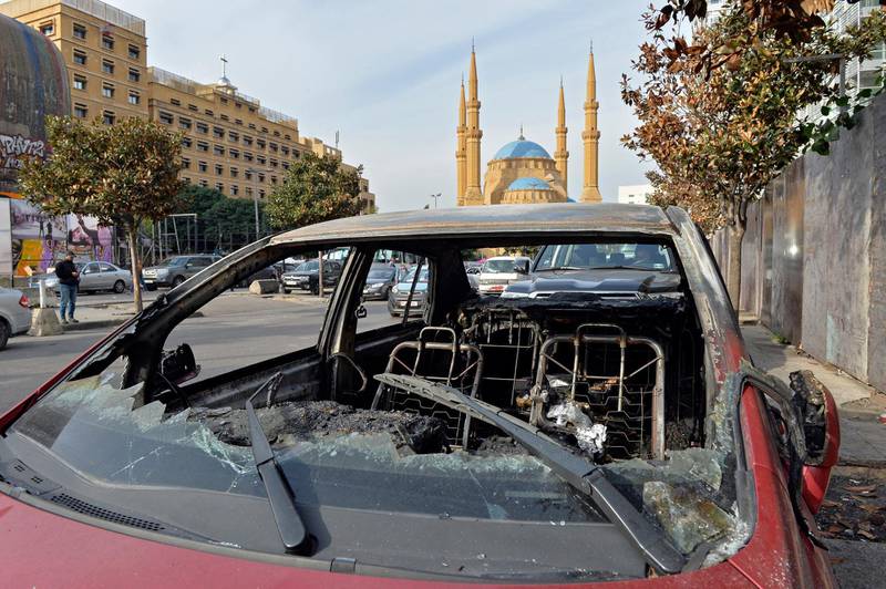 A burned car that was destroyed after a night of clashes between supporters of Hezbollah and Amal Movement with anti-government protesters in Beirut.  EPA