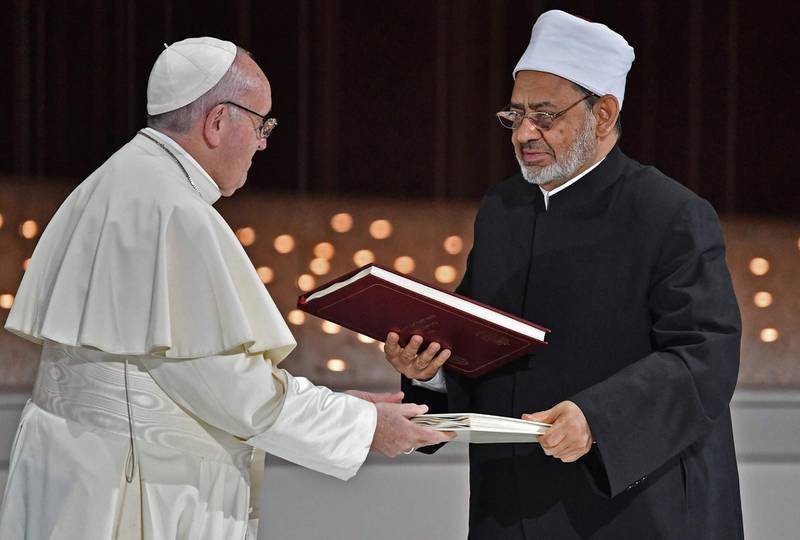Pope Francis and Egypt's Azhar Grand Imam Sheikh Ahmed al-Tayeb greet each other after signing documents during the Human Fraternity Meeting at the Founders Memorial in Abu Dhabi on February 4, 2019. Pope Francis rejected "hatred and violence" in the name of God, on the first visit by the head of the Catholic church to the Muslim-majority Arabian Peninsula. / AFP / Vincenzo PINTO                      
