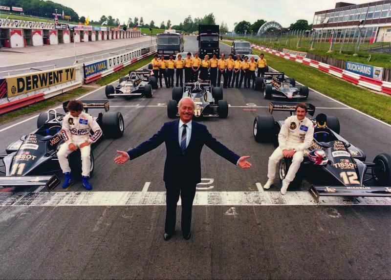 The founder of Lotus, Colin Chapman, centre, pictured in a typically flamboyant pose in 1981, at the head of a grid of his Team Lotus Formula One team, including, on the No 12 car, the future world champion Nigel Mansell. Courtesy of Lotus Cars