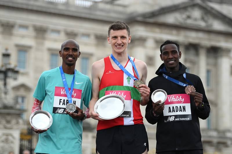 Race winner Ellis Cross, centre, second-placed Mo Farah, left, and Mohamud Aadan, right, on the podium in London. Getty
