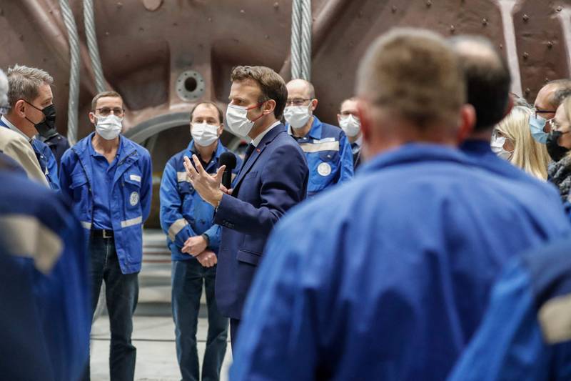 French President Emmanuel Macron talks to officials and workers at the GE Steam Power System main production site during a pre-election visit. AFP.