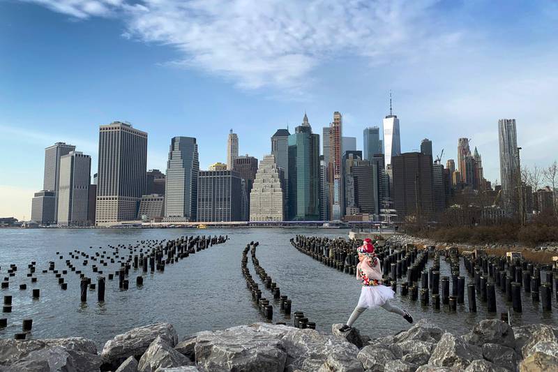With One World Trade Center seen in the background, a little girl leaps across boulders forming a breakwater along the Brooklyn Bridge Park, in the Brooklyn borough, of New York. AP Photo