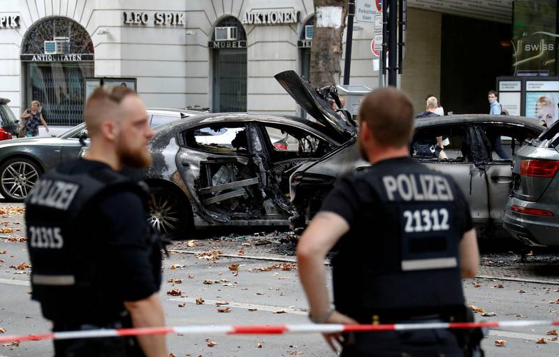 German police officers are seen beside burned cars at Kurfurstendamm boulevard in Berlin, Germany, August 8, 2018. REUTERS/Fabrizio Bensch