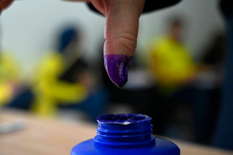 A woman dips her finger in indelible ink after casting her ballot at a polling station in Beirut, Lebanon. EPA