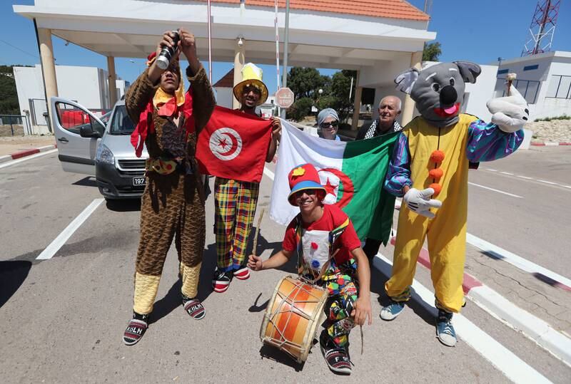Algerian tourists taking a photo with Tunisian clowns after entering at the Malloula border post near Tabarka, on the first day of its reopening, in north-western Tunisia on 15 July 2022.  Closed since the Covid-19 crisis in 2020, Algeria is proceeding on 15 July to reopen its land border with its neighbor Tunisia, one of the preferred destinations for Algerians.   EPA / MOHAMED MESSARA